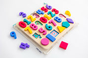 Domino & Juliette numbers puzzle with pieces removed, stacked on top of a Domino & Juliette 123 puzzle bag