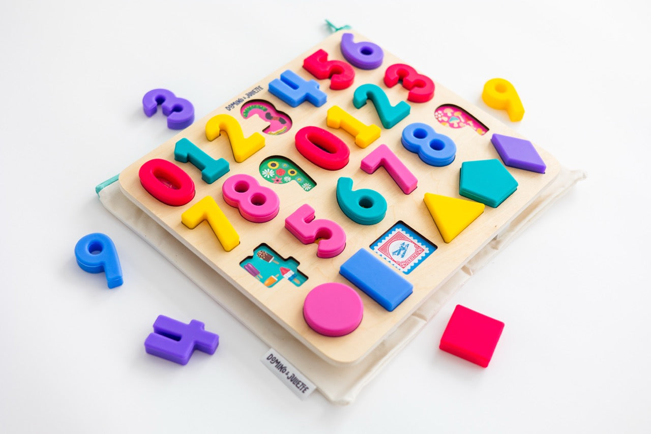 Domino & Juliette numbers puzzle with pieces removed, stacked on top of a Domino & Juliette 123 puzzle bag